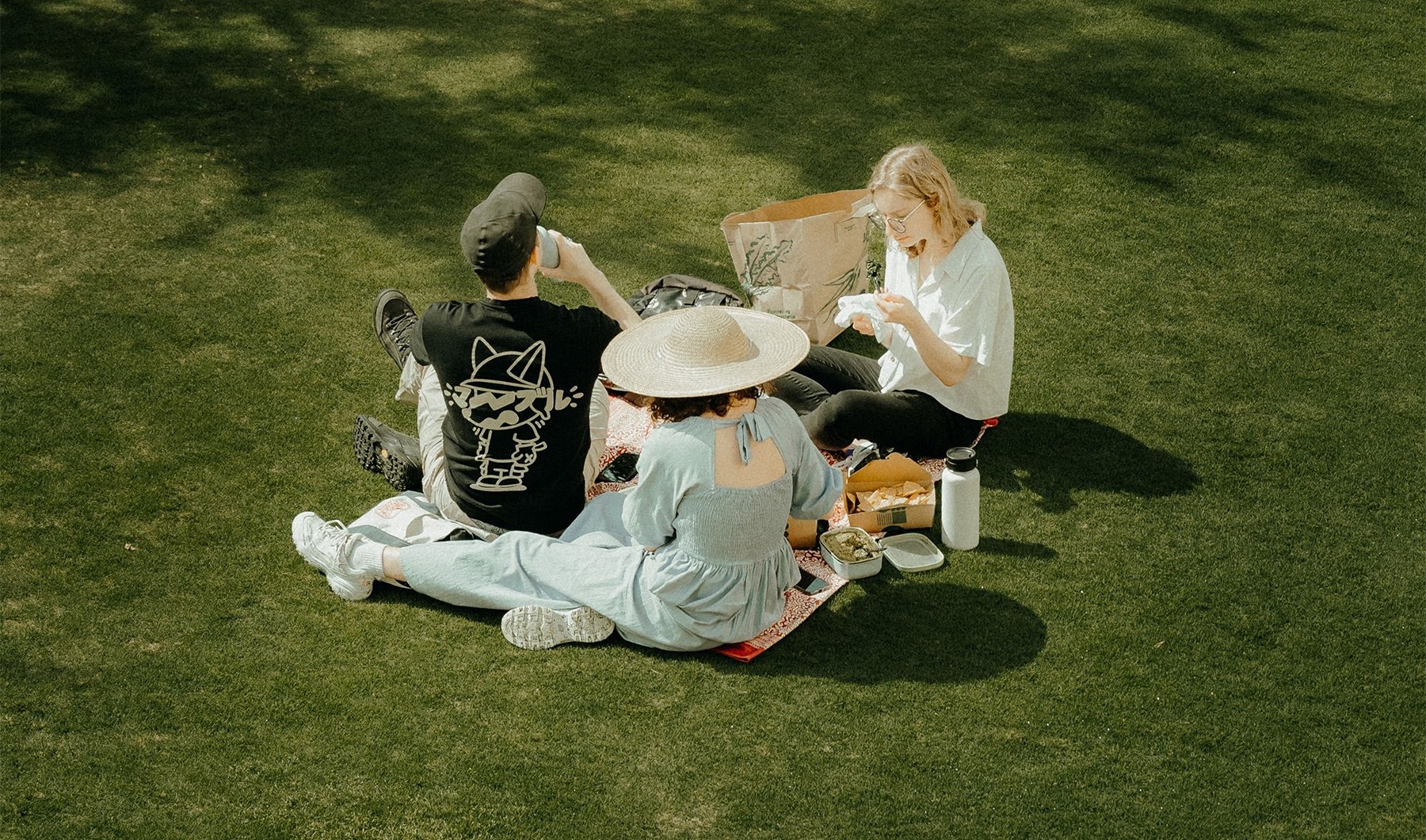 a group of people sitting on the grass